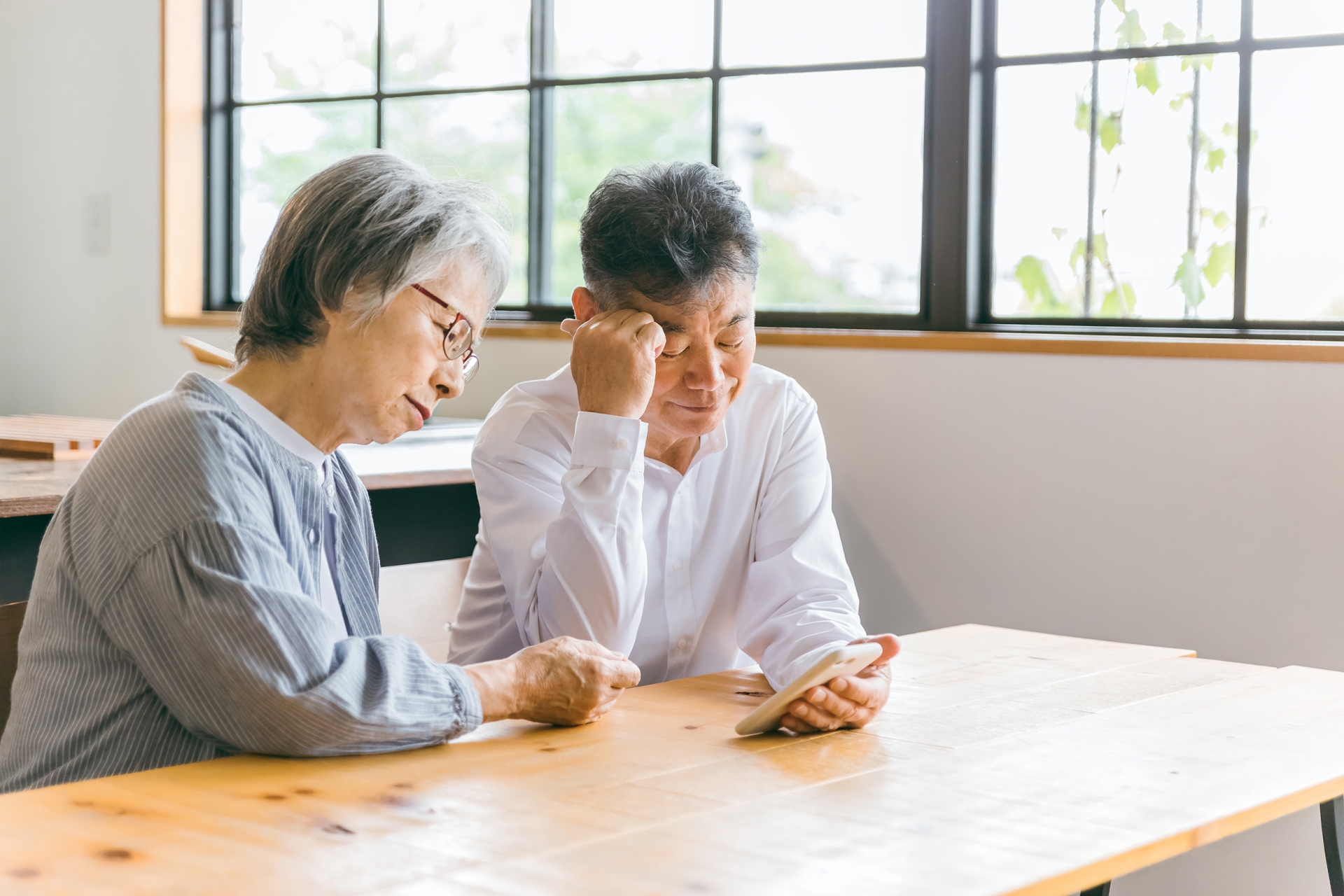 スマホを使う困るアジア人高齢者夫婦
